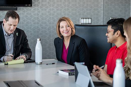 accounting professor with students at conference table