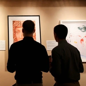 Two people viewing art in a gallery.