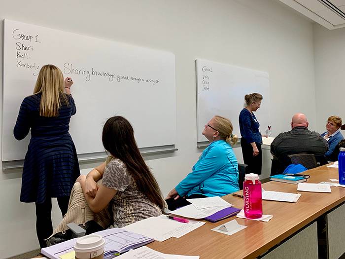 Kelli Gast (at white board), Kimberly Williams, Sheri Altepeter, Vicky Pizzey, Craig Burns, Janet Jedlicka
