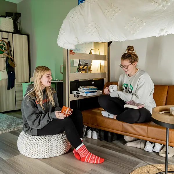 2 female students enjoying coffee in their dorm room