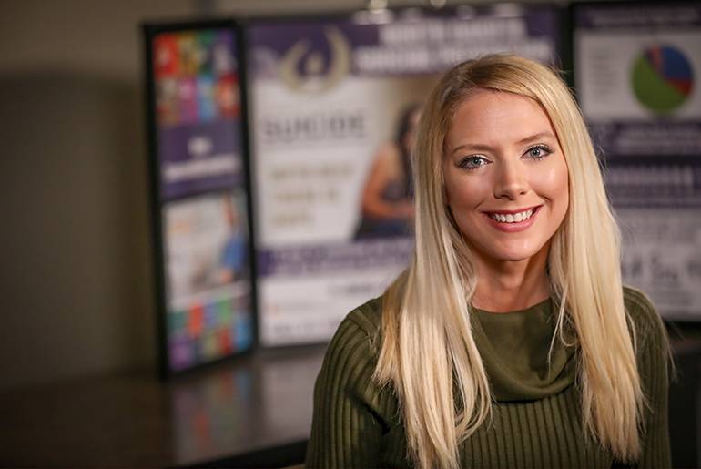 Alison Traynor in front of suicide prevention poster