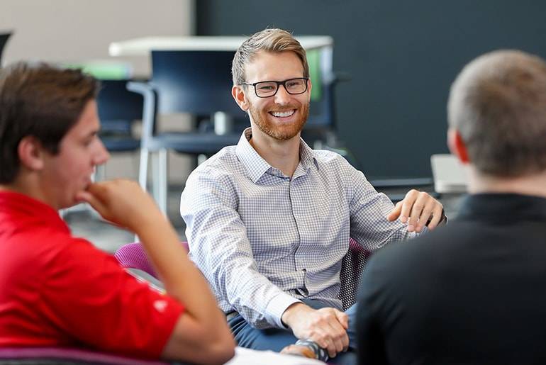 Greg smiles while talking with group