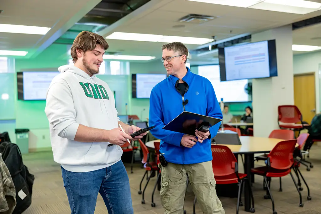 mason walking in library with other students