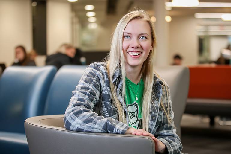 Olivia Taylor smiling in a chair