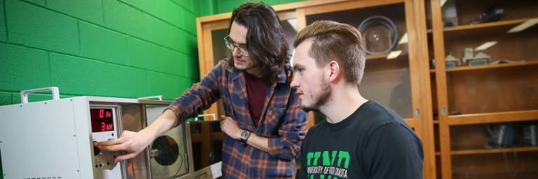 two physics students looking at research station
