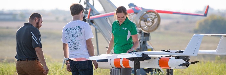 unmanned aircraft system operations students inspecting a drone