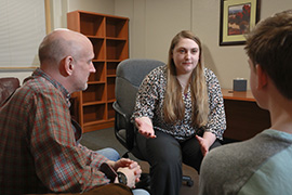 Counselor talks to a male and female adult.