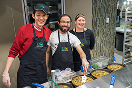 students cooking food at a dining event