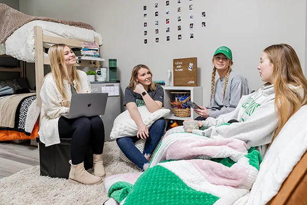 4 female UND students visit in their dorm room