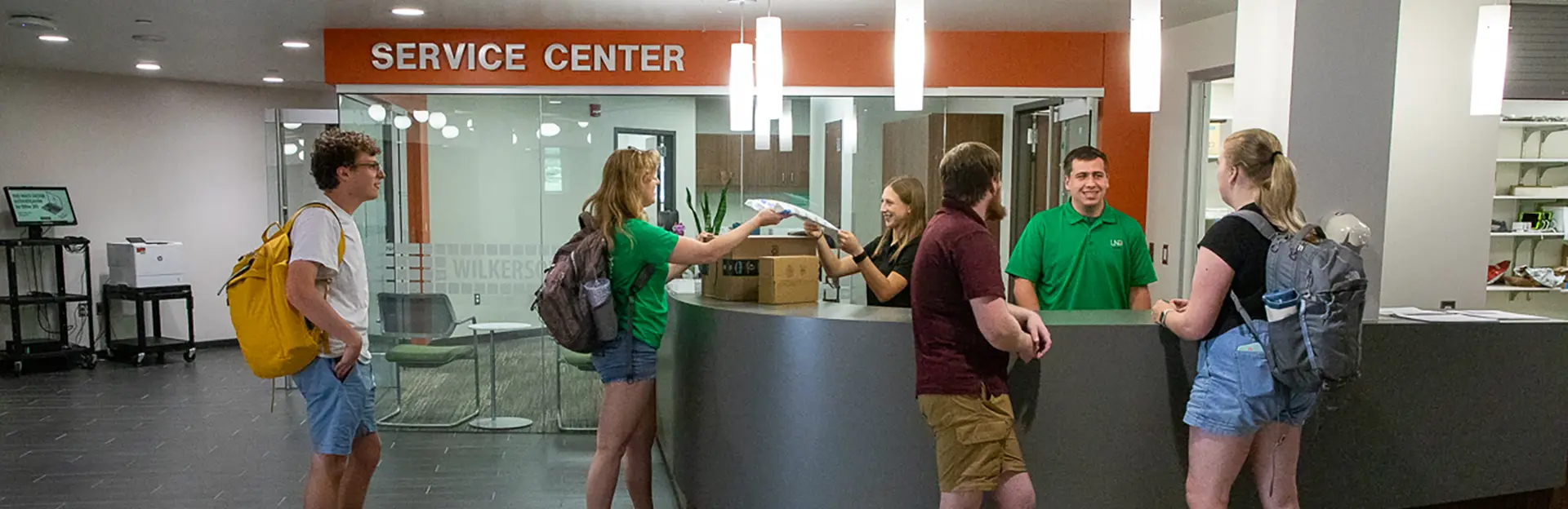 Students receiving packages at Wilkerson Service Center and talking to staff.