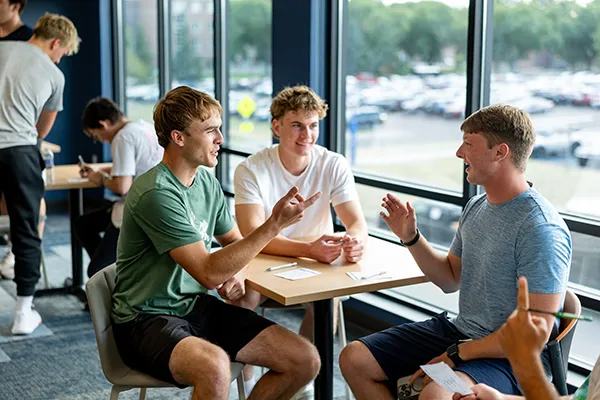 3 male UND students visit in residence hall common area