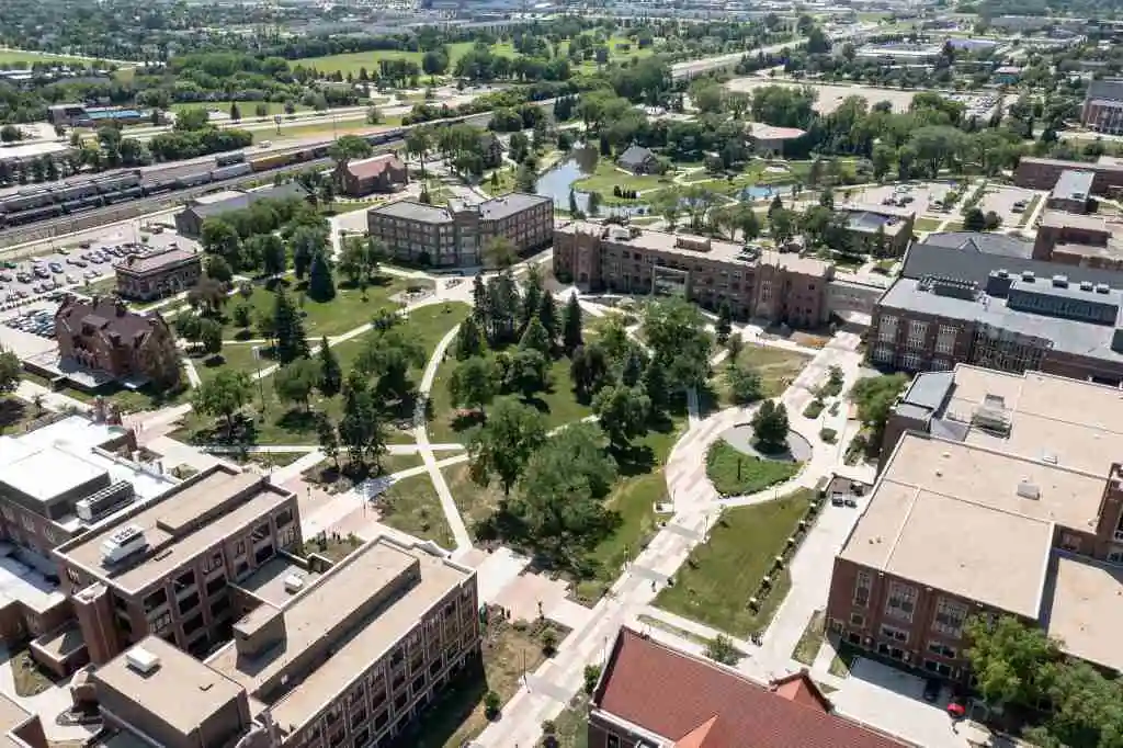 Aerial view of a university campus with buildings, pathways, and green spaces.